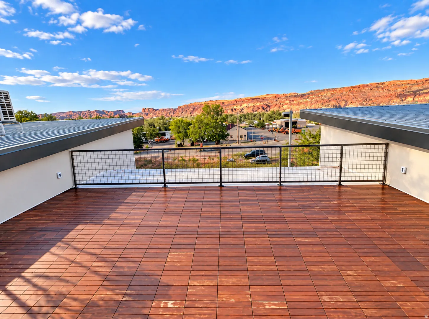Rooftop deck featuring wood-finish tile flooring and metal grid railing