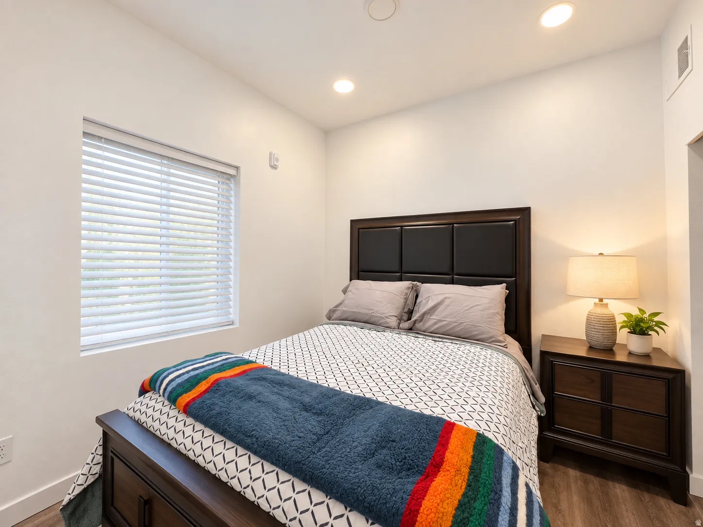 Recessed lighting, wood-finish flooring, and a window with horizontal blinds