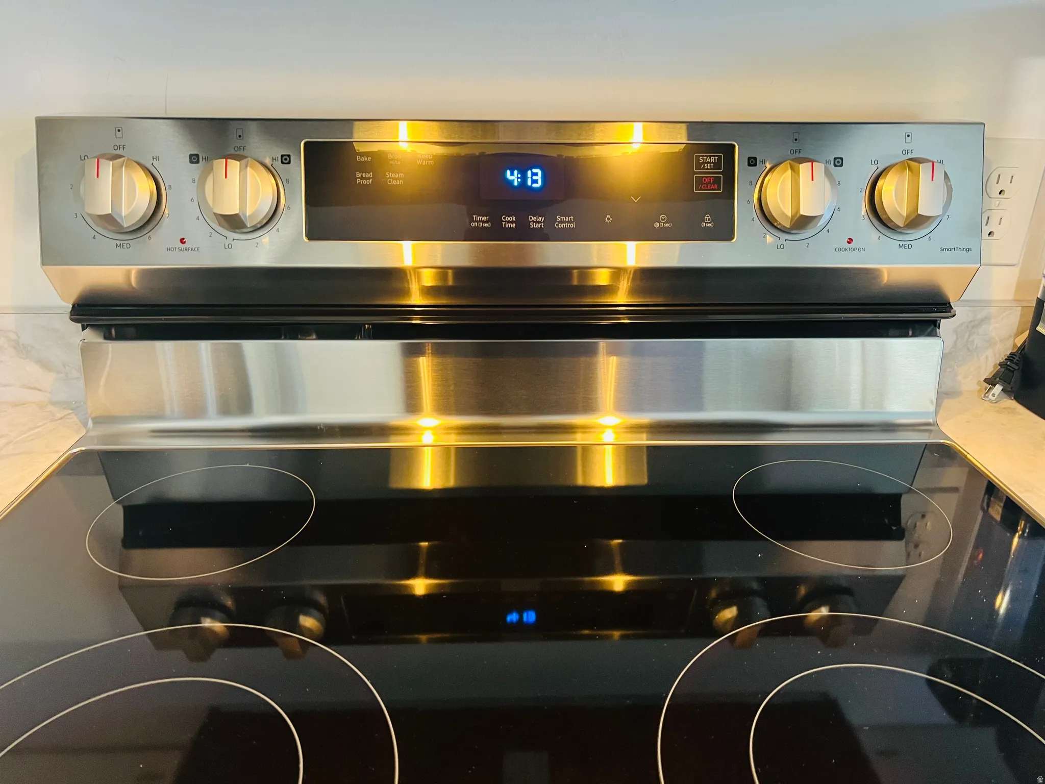 Stainless steel range with a smooth cooktop surface and digital display