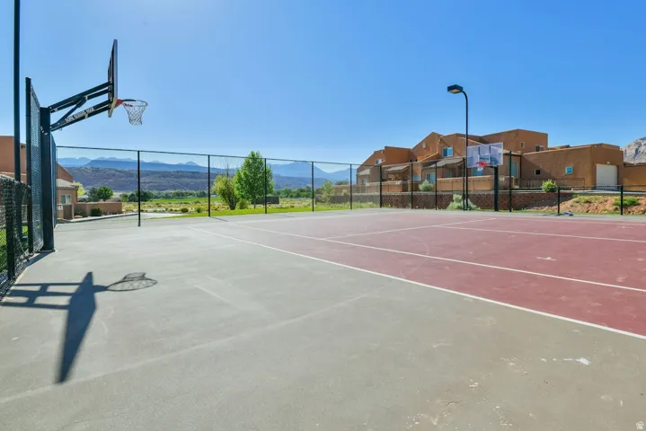 Multi-sport court featuring a basketball hoop and tennis net