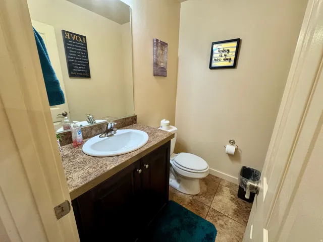 Bathroom featuring a vanity with a laminate countertop, integrated sink, and dark wood-finish cabinetry