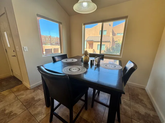 Tiled flooring with a neutral finish, vaulted ceiling, and dual windows