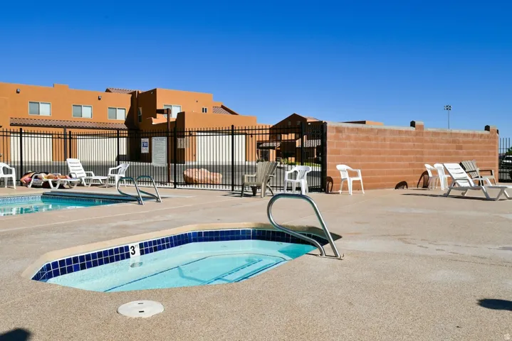 Outdoor spa with blue tile accents, surrounded by a concrete deck