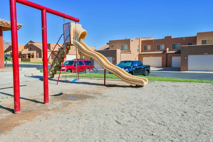 Community playground with sand ground cover and a slide structure