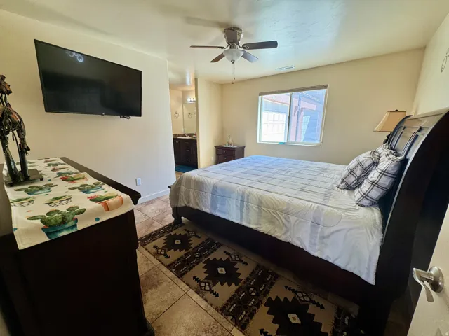 Recessed window with blinds, ceiling fan, and tile flooring throughout