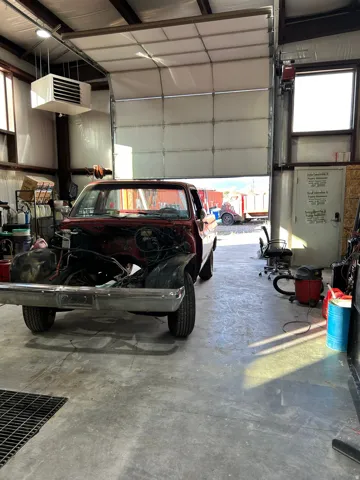 Metal beam construction building with a concrete floor, large overhead door, and a wall-mounted window
