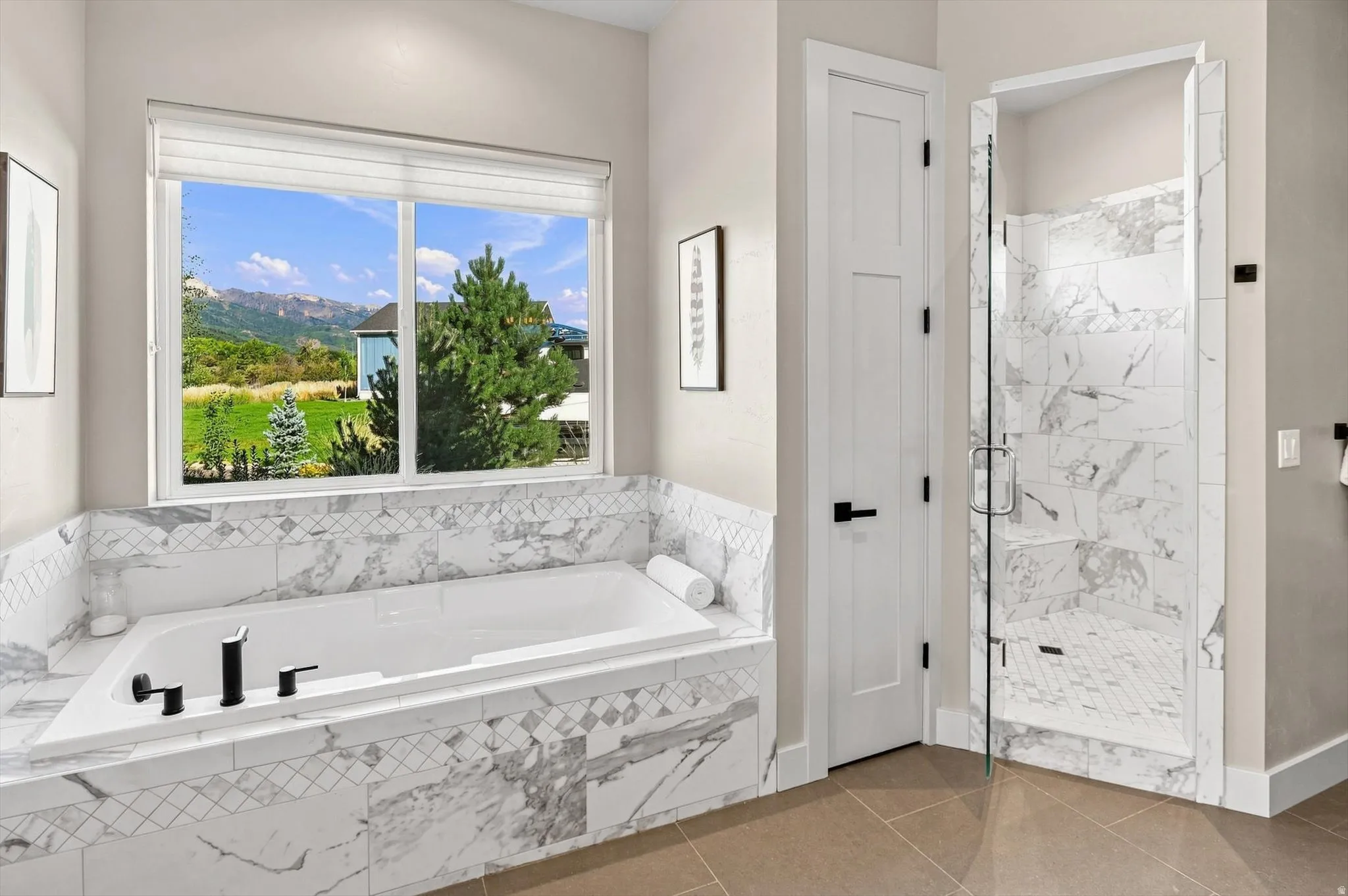 Built-in soaking tub with a tiled surround, separate glass-enclosed shower with tile, and large window