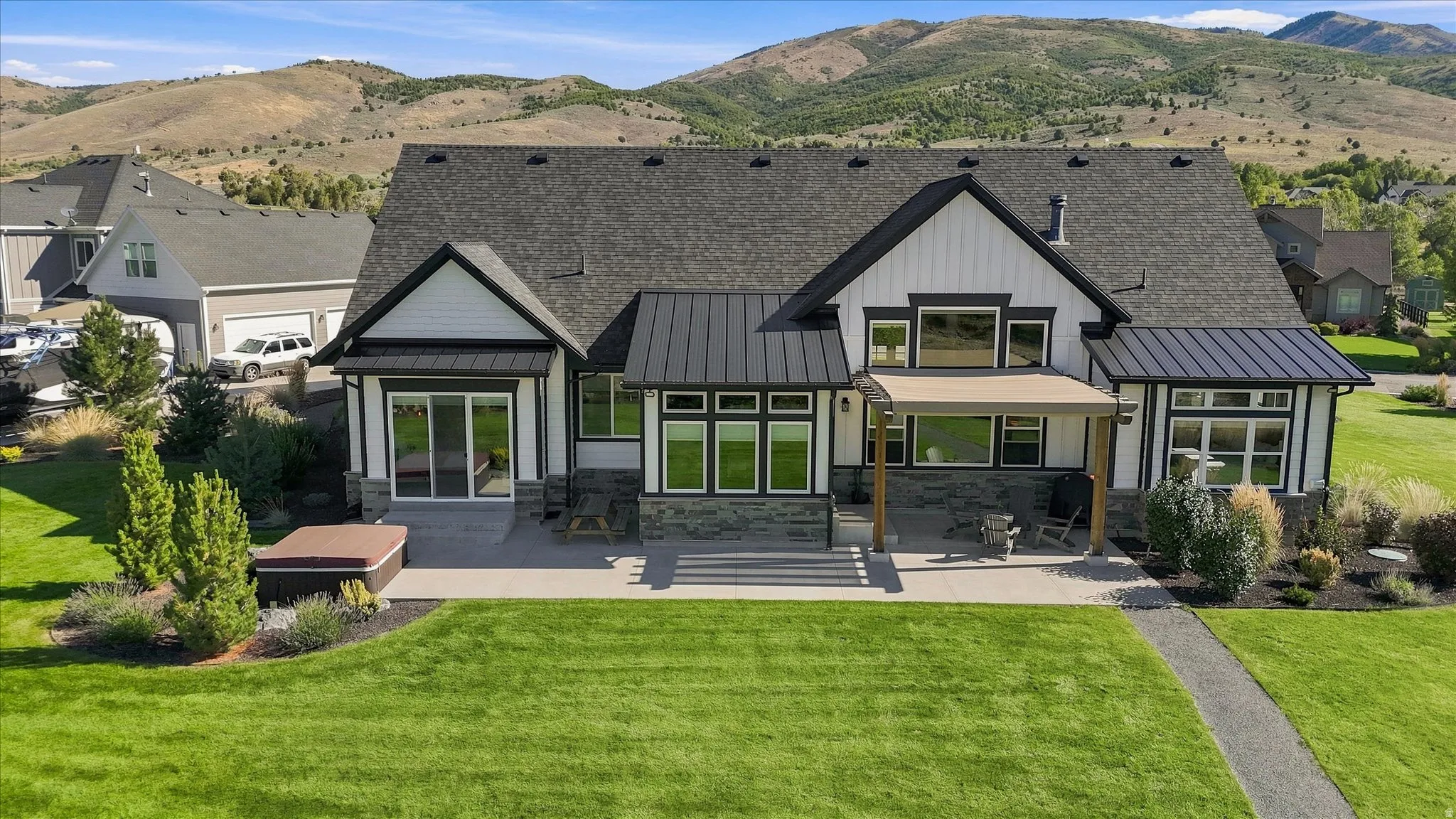 Modern farmhouse exterior with board and batten siding, stone accents, and dark-framed windows