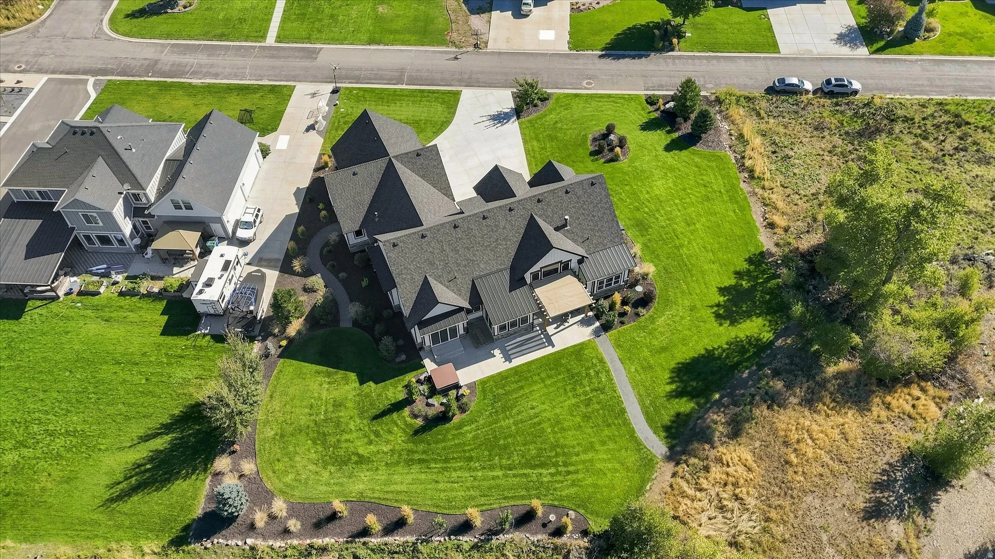 Expansive lot featuring a large residence, manicured lawns, paved driveways, and mature landscaping