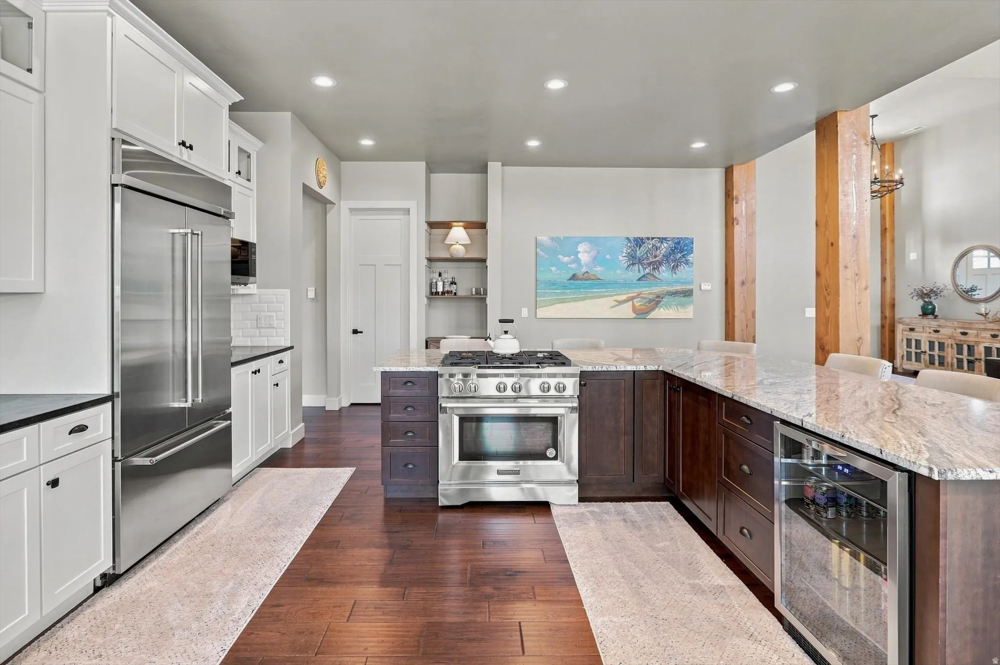 Kitchen featuring wood-finish flooring, two-tone cabinetry, stainless steel appliances, granite countertops, and recessed lighting