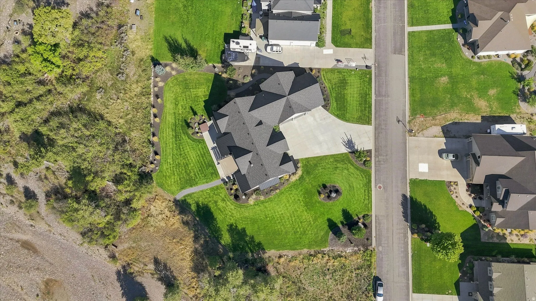 Expansive residential property featuring a multi-gabled roofline, concrete driveway, and manicured lawns