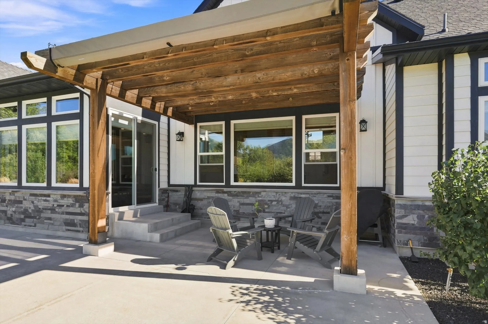 Patio with a wood pergola, concrete surface, and multi-pane windows