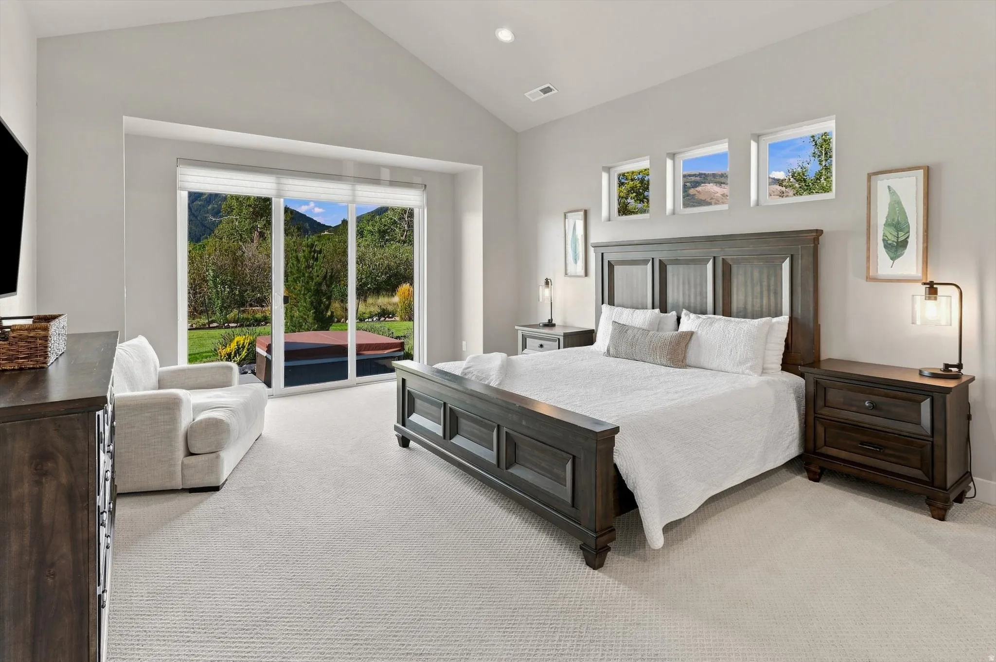 Vaulted ceiling, carpeted flooring, and a large sliding glass door