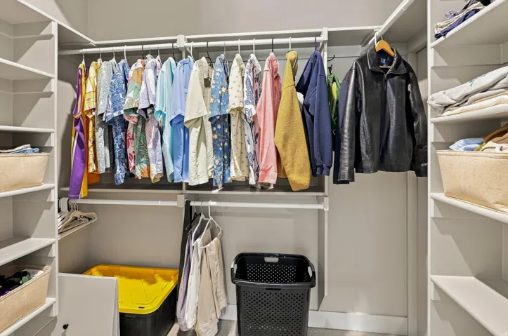 Built-in closet system featuring multiple hanging rods, extensive shelving, and integrated corner storage