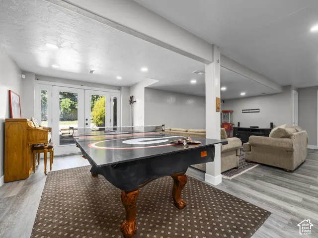 Spacious lower-level area with recessed lighting, light-toned walls, and wood-finish flooring