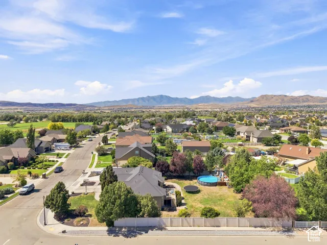 Residential neighborhood with mature trees, established landscaping, and mountain backdrops