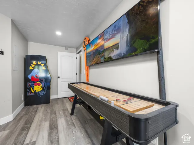 Wood-finish flooring with white trim and a paneled interior door