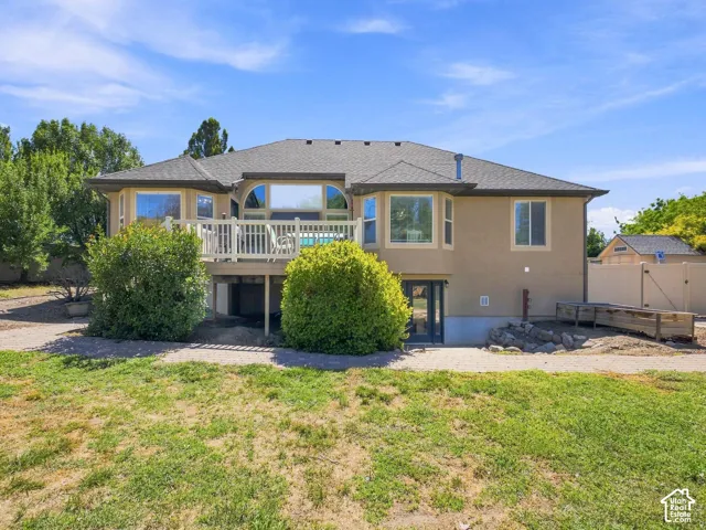 Rear exterior with an upper-level deck, lower-level patio, and a separate storage shed