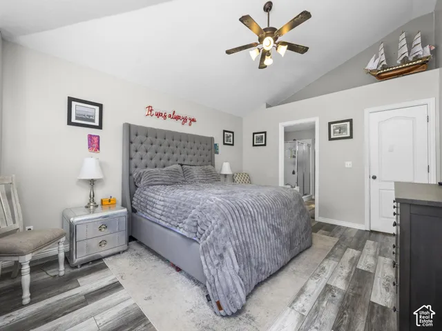 Vaulted ceiling with a ceiling fan, wood-finish flooring, and white interior doors