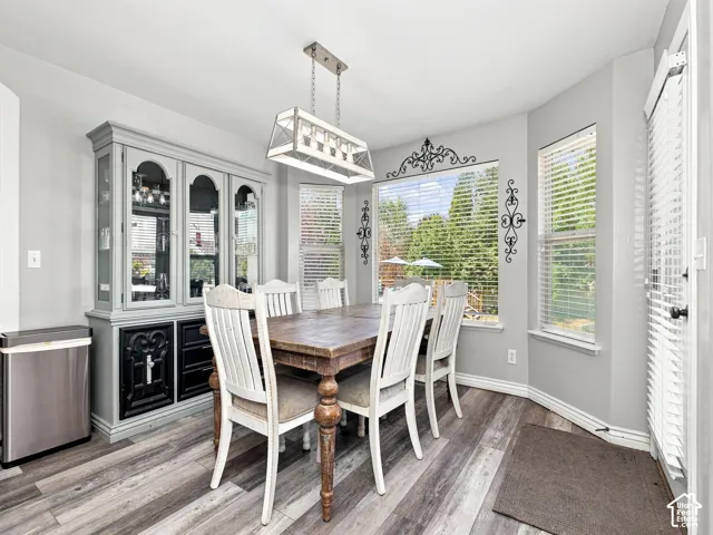 Wood-finish flooring, built-in display cabinetry, and a multi-paned window with horizontal blinds