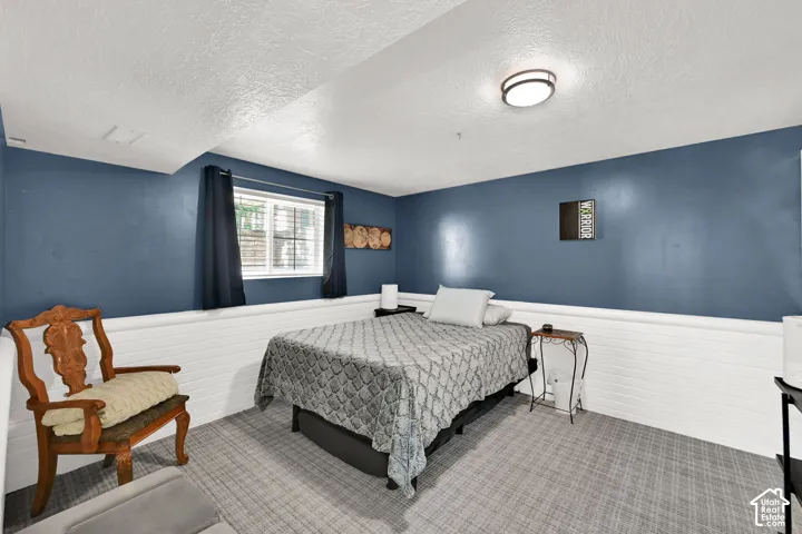 Window with blinds, wall-mounted light fixture, and two-tone wall treatment with lower paneling