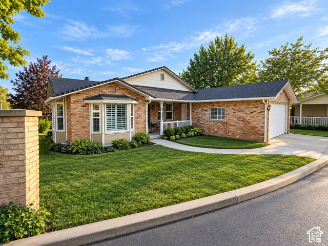 Brick exterior with a white garage door and a covered front porch
