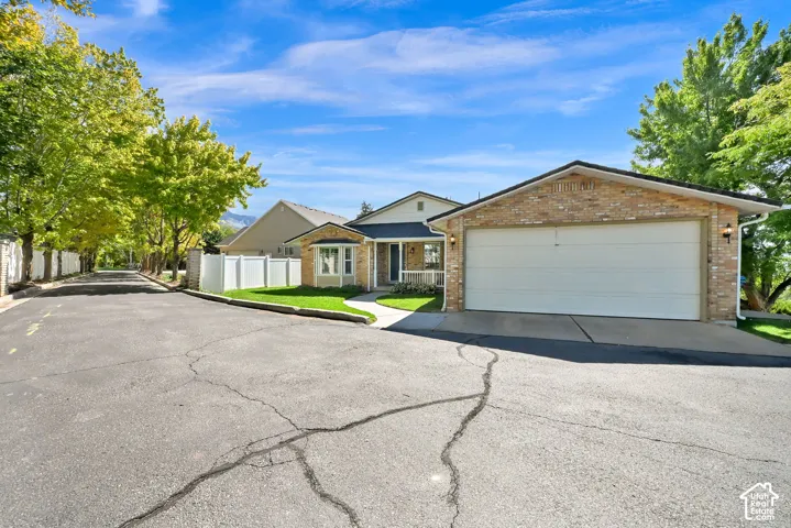 Brick-clad garage with a two-car capacity, front-facing bay window, and a covered porch entry