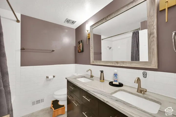 Dual vanity with integrated sinks, brushed nickel fixtures, dark wood-finish cabinetry, and a large framed mirror