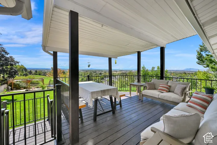 Covered outdoor deck with composite decking, black metal railings, and clear sky