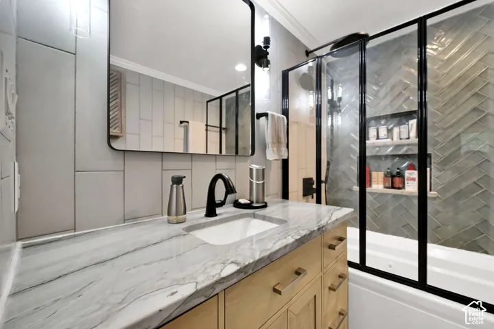 Vanity with a patterned countertop, wood-finish cabinetry, and a single basin sink