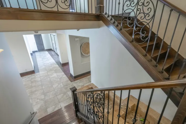 Sweeping staircase with ornate wrought iron balusters and dark wood-finish treads