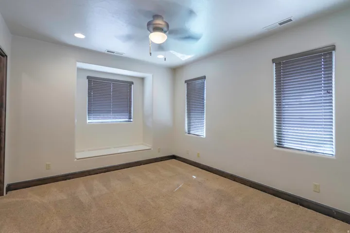 Recessed window with a built-in sill, two additional windows with blinds, recessed ceiling lighting, and a ceiling fan