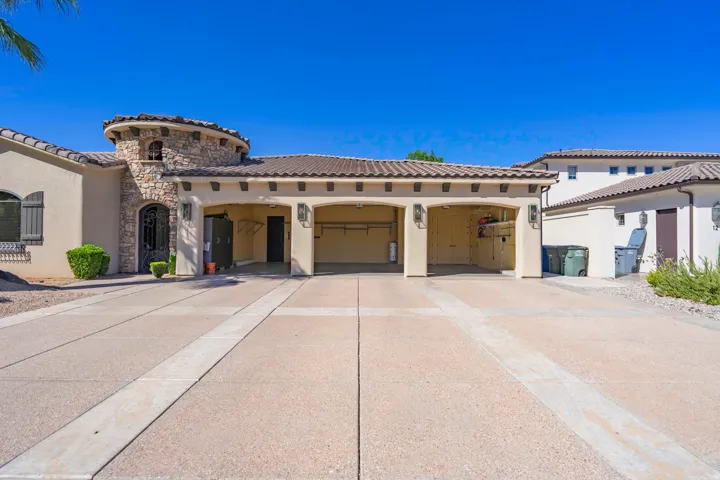 Stucco exterior with a stone-clad turret, arched entry, and tiled roof
