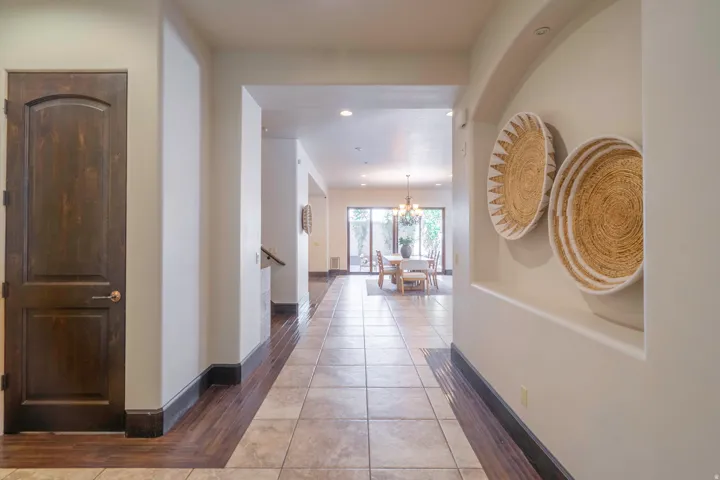 Arched entryways, recessed ceiling lighting, wood-finish flooring, tiled flooring, and a dark wood door