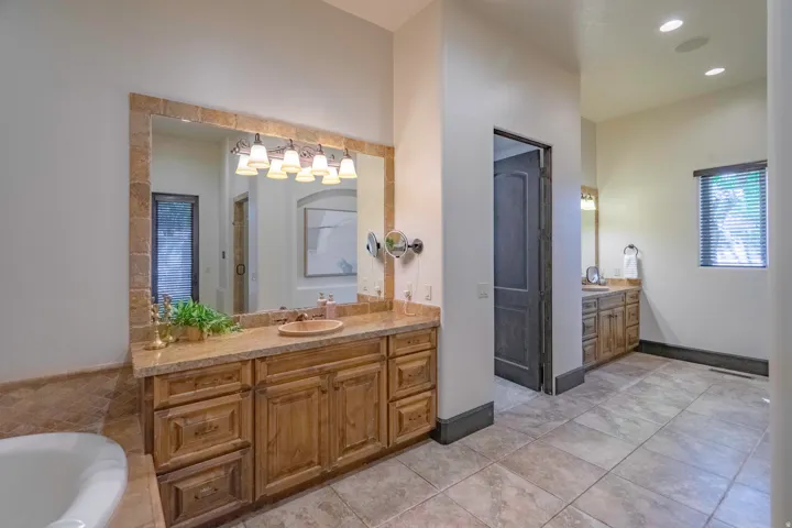 Dual vanity with wood-finish cabinetry and stone countertops