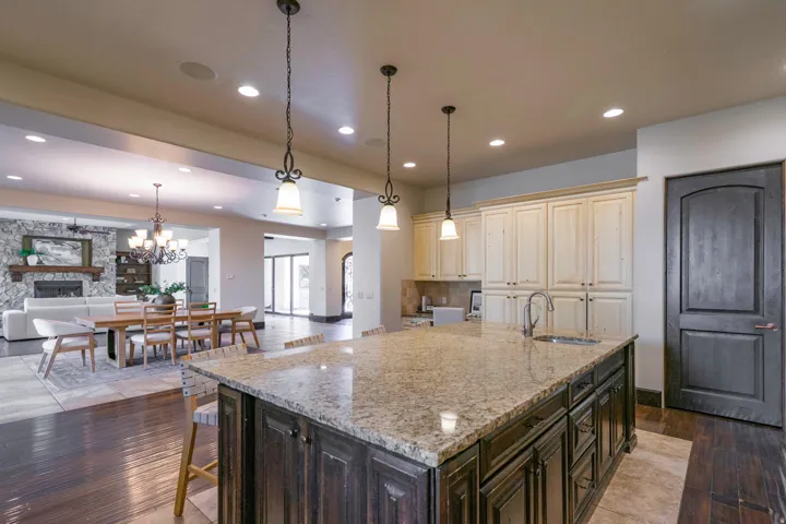 Kitchen island with a light-toned countertop, dark wood-finish cabinetry, and an integrated sink