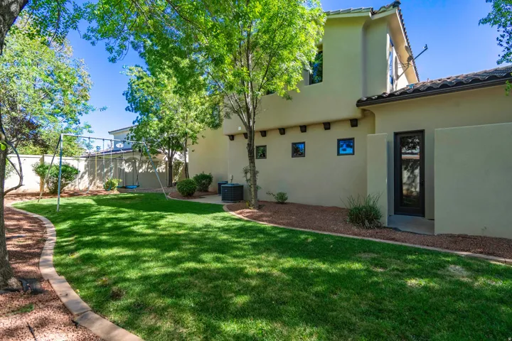 Manicured lawn with mature trees and a privacy wall