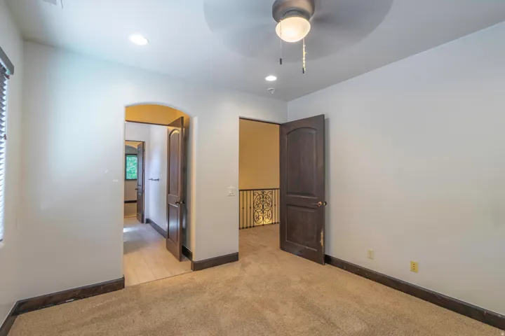 Arched doorway, ceiling fan, recessed lighting, carpeted flooring, wood-finish doors