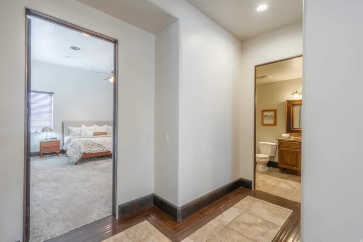 Recessed lighting and wood-finish flooring in the hallway
