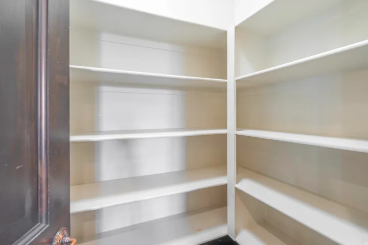 Pantry with multiple white shelves