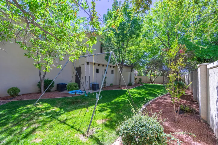 Expansive backyard featuring a manicured lawn, and  established shade trees
