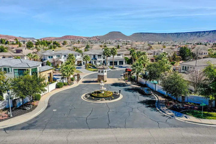 Gated community entrance with a decorative fountain and landscaped island