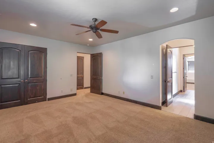 Recessed lighting, ceiling fan, brown wood-finish doors, brown wood-finish trim, and carpeted flooring