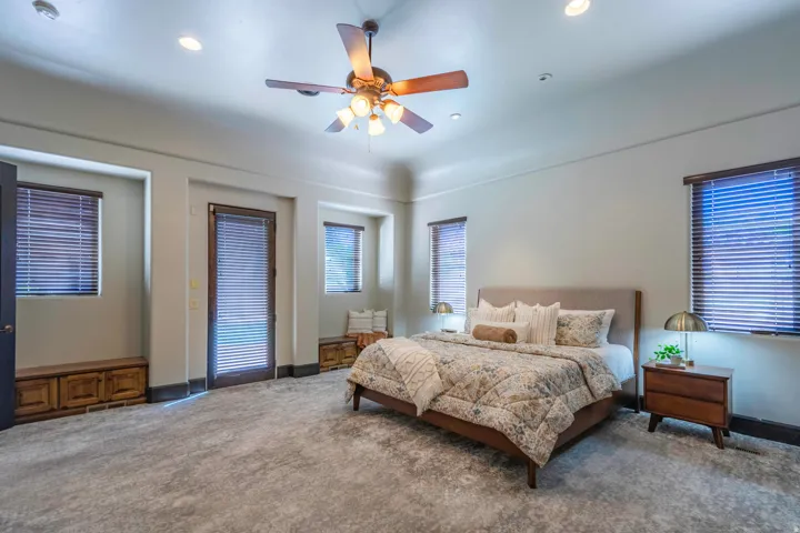 Recessed lighting, ceiling fan with light fixture, light-toned wall finishes, built-in wooden storage, and a glass-paneled door