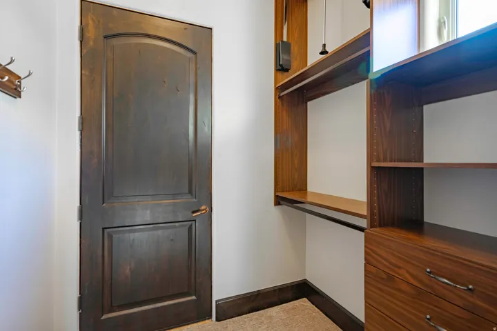 Built-in closet system featuring multiple shelves, hanging rods, and drawers with metal hardware