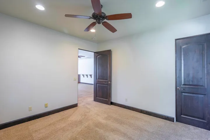 Recessed lighting, wood-finish ceiling fan, wood-finish trim, and wood-panel doors