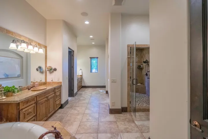 Dual vanity with integrated sinks, wood-finish cabinetry, and sconce lighting