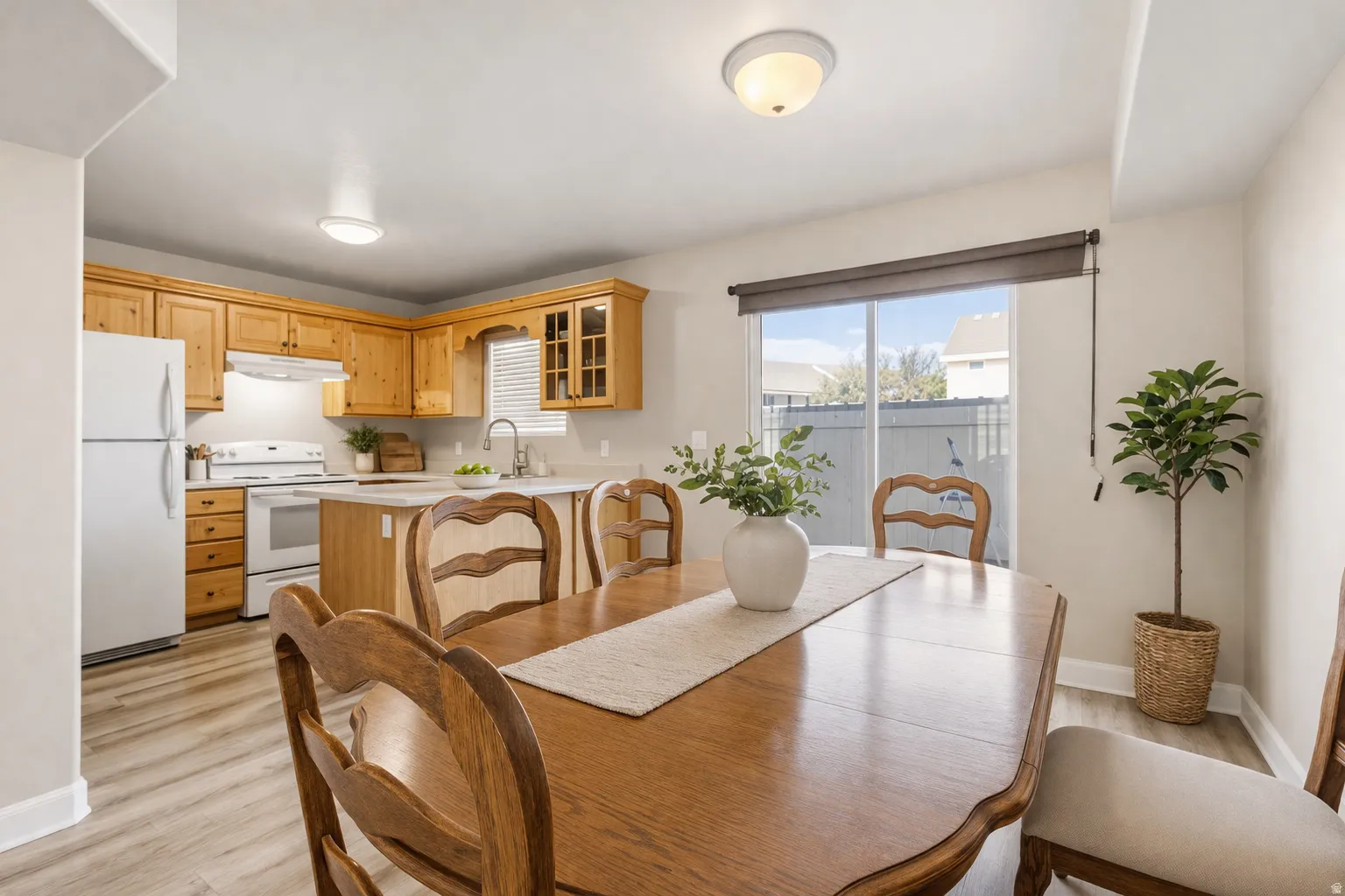 Kitchen featuring wood cabinetry, white appliances, and a central island
