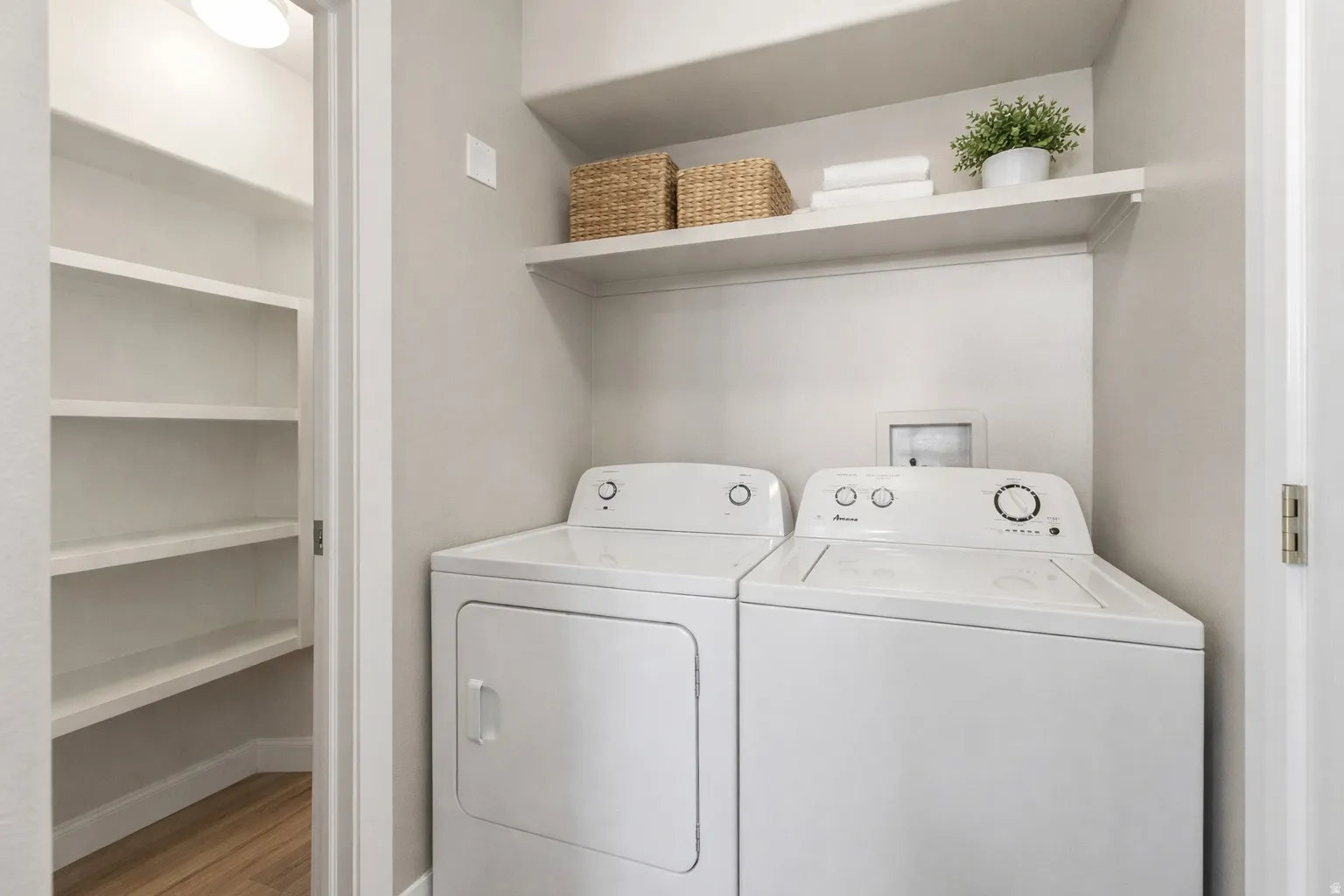 Dedicated laundry area with built-in shelving, providing functional storage