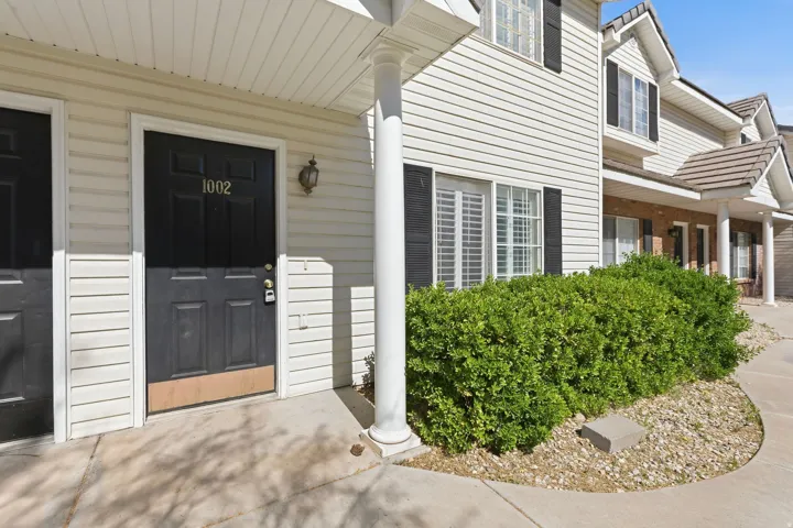 White siding exterior with black shutters and a black paneled entry door